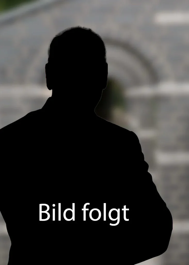 Portrait von René Gerard, der einen dunklen Pullover trägt und in die Kamera lächelt.